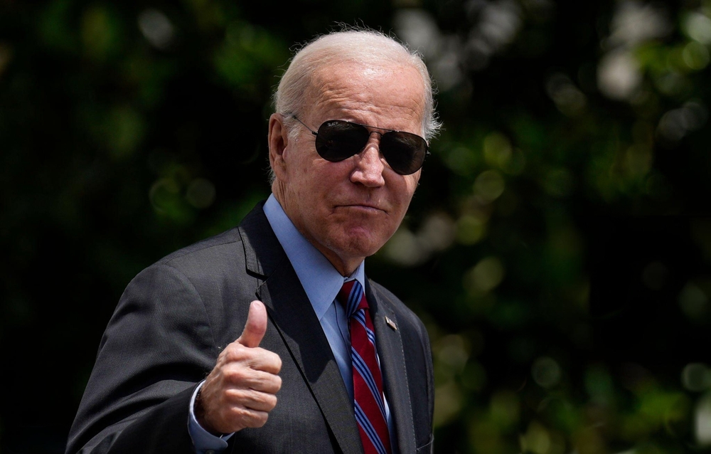 Man in suit with sunglasses gives thumbs up