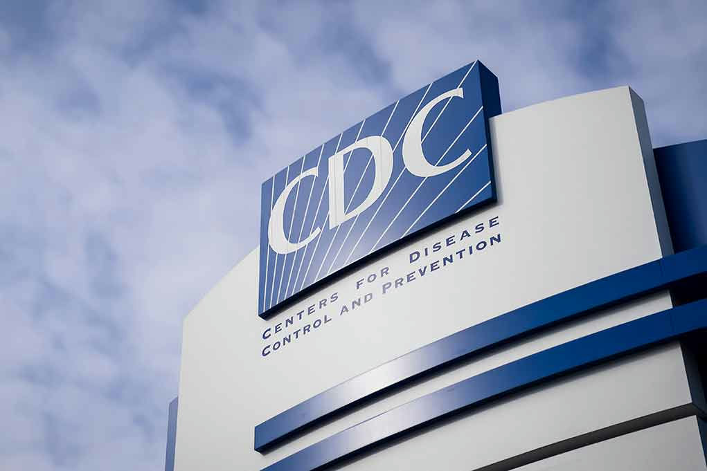CDC sign on building with cloudy sky background.