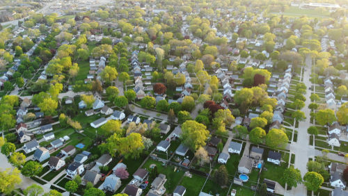 Aerial view of a suburban neighborhood with green trees.