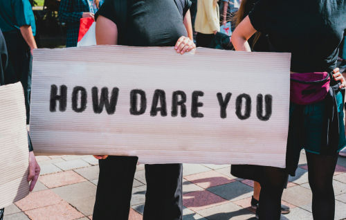 Person holds sign reading 