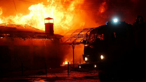 Building on fire with a firetruck in foreground.