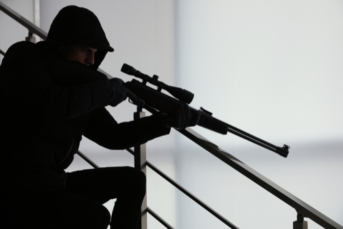 A silhouetted figure in tactical gear aiming a sniper rifle from a staircase