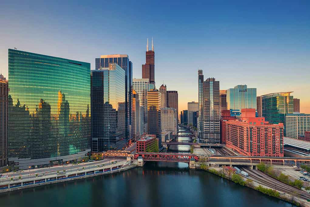 Skyscrapers along a river at sunset.