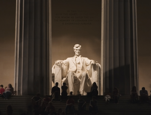Night view of the Lincoln Memorial with a statue of Abraham Lincoln seated